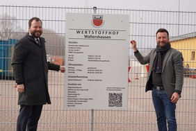 Landrat Onno Eckert und KAS-Leiter Sebastian Fischer haben gemeinsam das neue Schild am Wertstoffhof angebracht. 